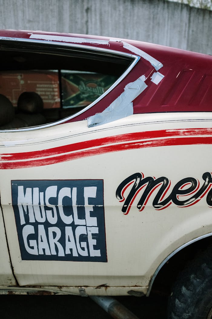 Close-up of a retro muscle car with Muscle Garage signage on the door.